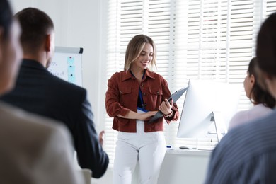 Photo of Woman giving public speech in front of audience indoors