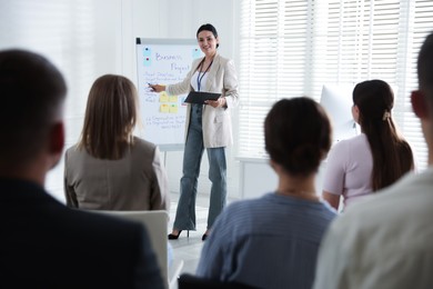 Photo of Woman giving public speech in front of audience indoors