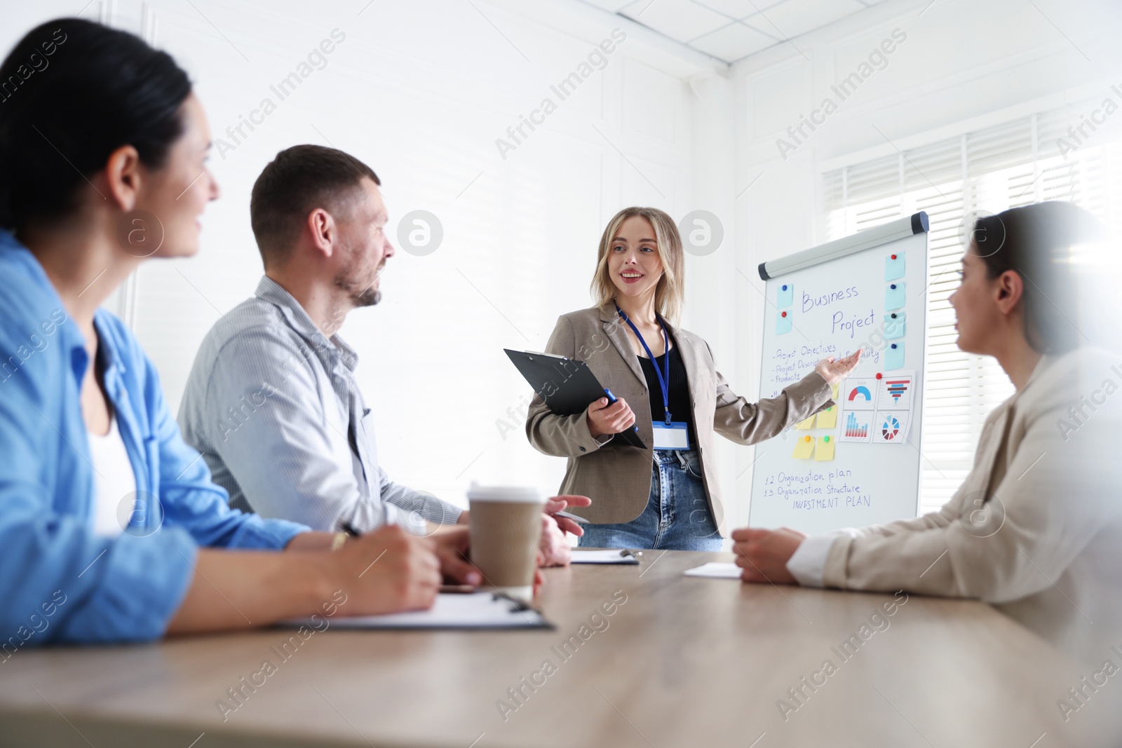 Woman giving public speech in front of audience indoors Photo of Woman giving public speech in front of audience indoors
