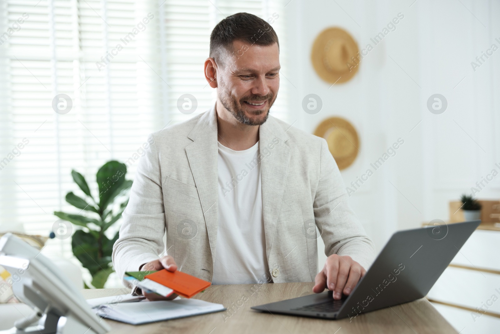 Travel agent with passports and tickets at wooden table in office Photo of Travel agent with passports and tickets at wooden table in office