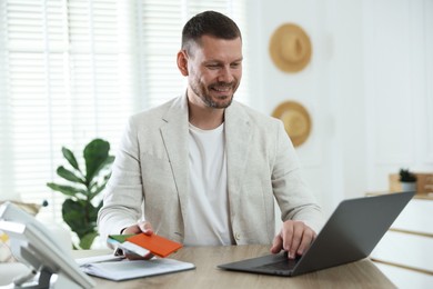 Photo of Travel agent with passports and tickets at wooden table in office