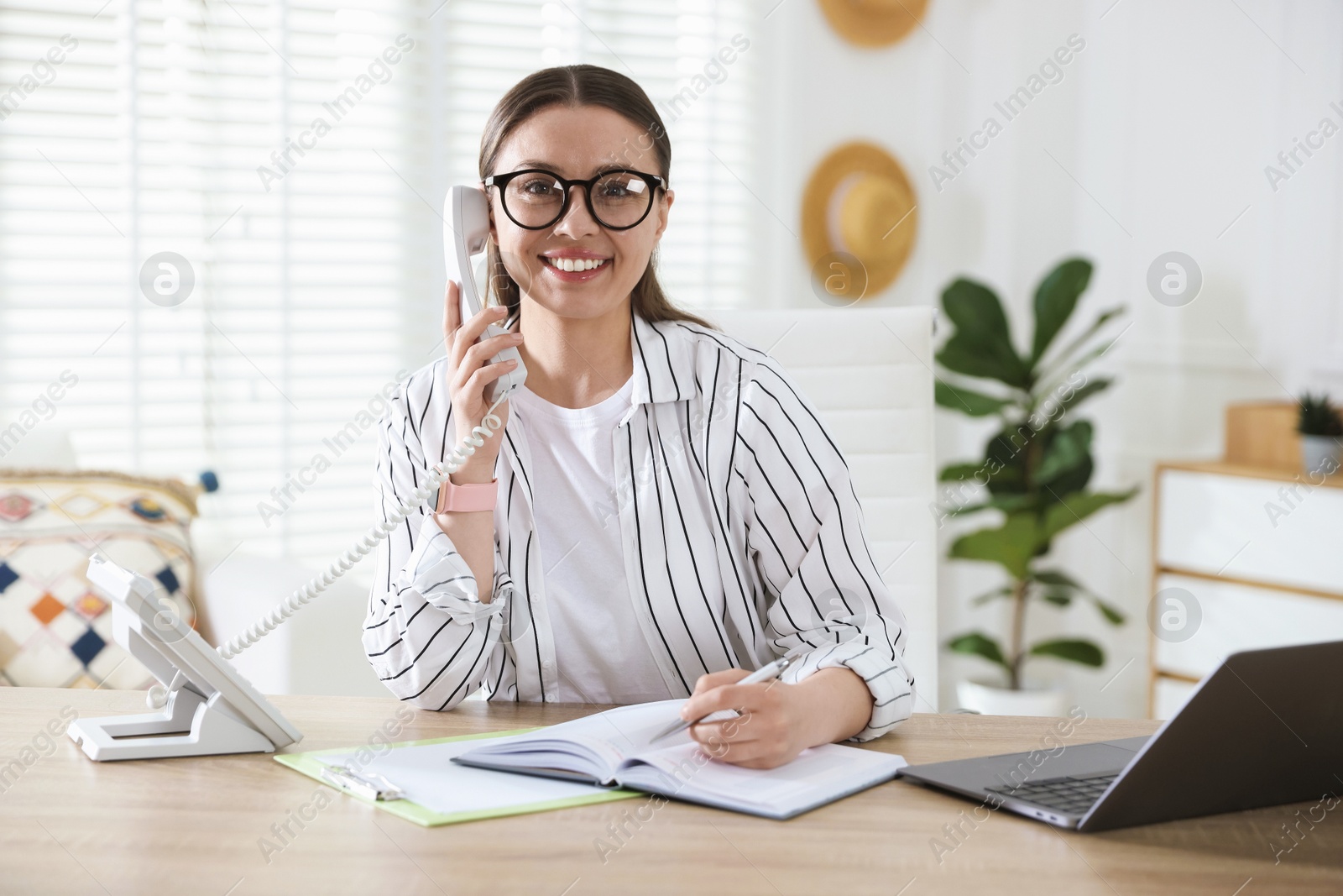 Travel agent working at wooden table in office Photo of Travel agent working at wooden table in office