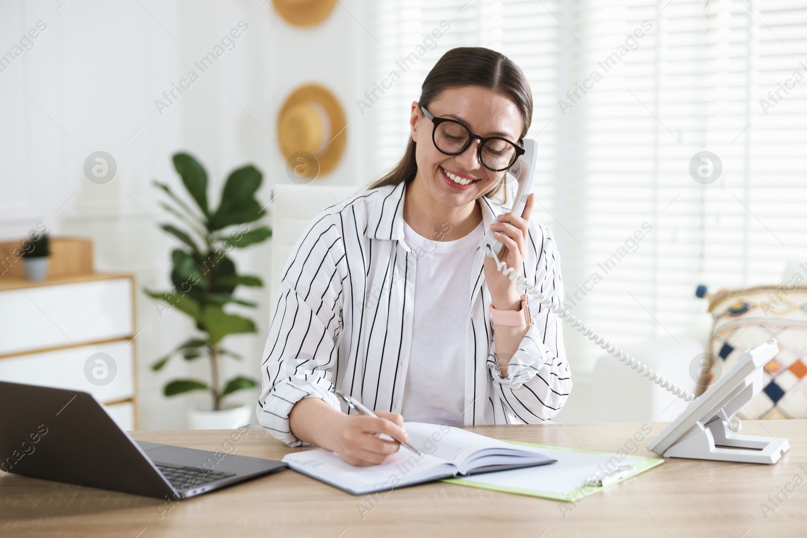 Travel agent working at wooden table in office Photo of Travel agent working at wooden table in office