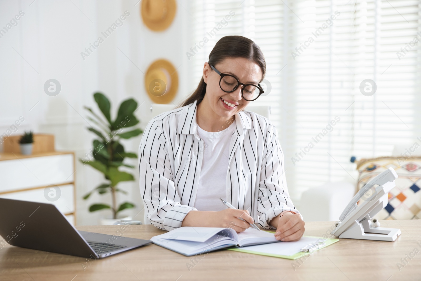 Travel agent working at wooden table in office Photo of Travel agent working at wooden table in office