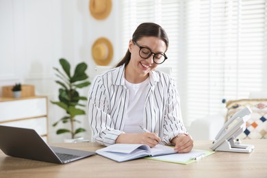 Photo of Travel agent working at wooden table in office