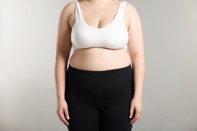 Photo of Weight loss. Plus size woman on gray background, closeup