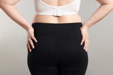 Photo of Weight loss. Plus size woman on gray background, closeup