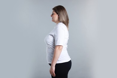 Photo of Weight loss. Plus size woman on gray background, space for text