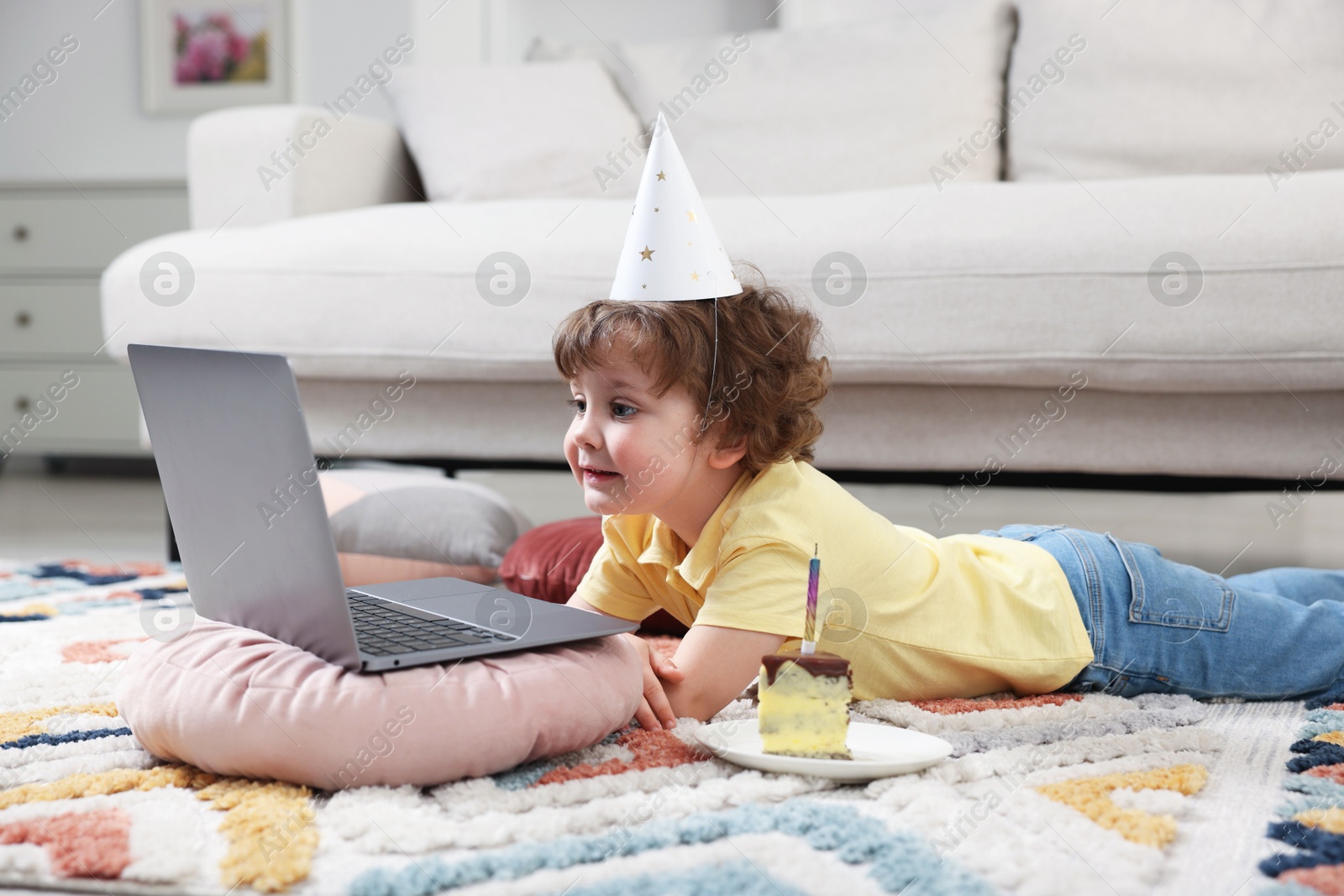 Birthday celebration. Little boy with piece of cake having video call via laptop at home Photo of Birthday celebration. Little boy with piece of cake having video call via laptop at home