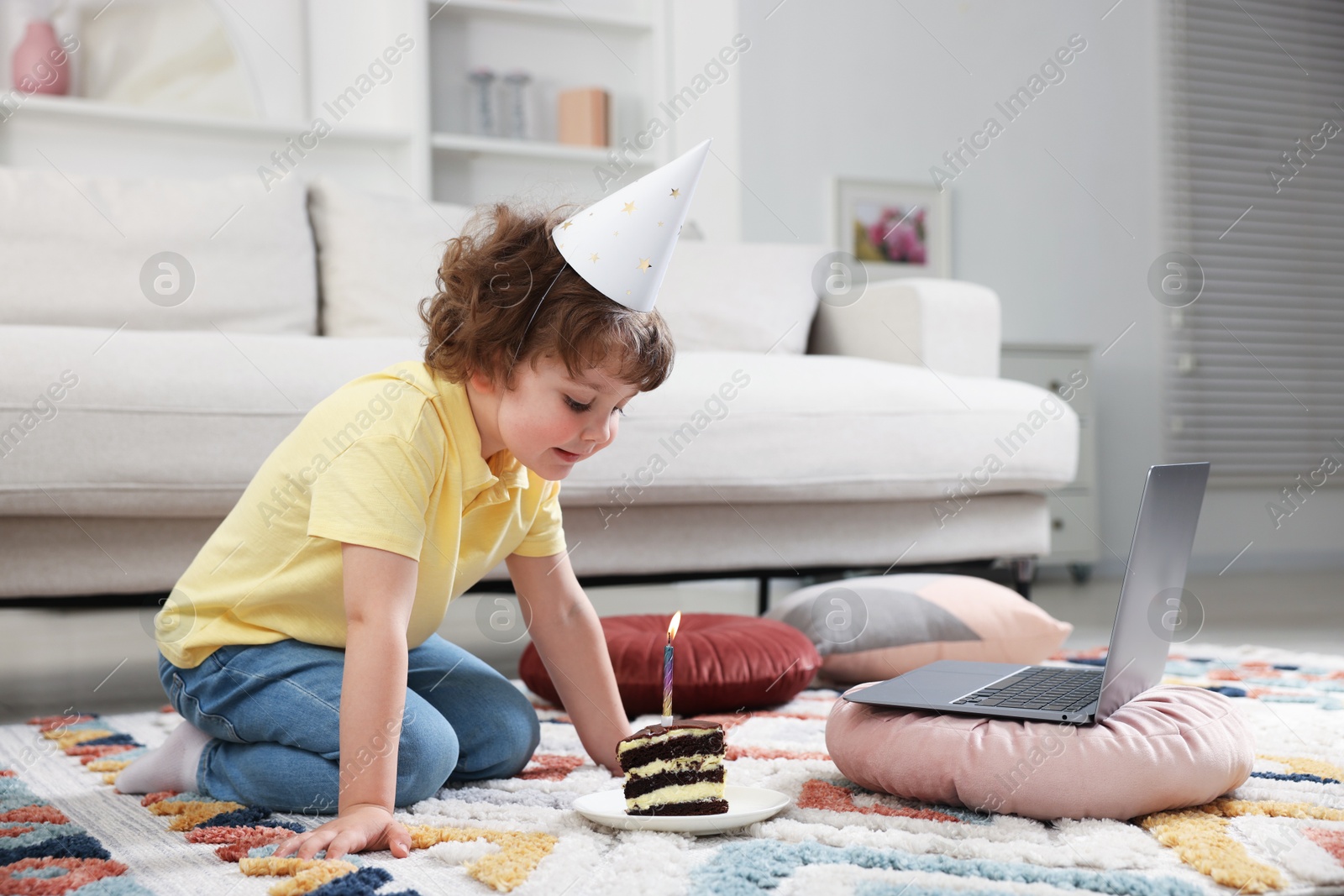 Birthday celebration. Little boy with piece of cake having video call via laptop at home Photo of Birthday celebration. Little boy with piece of cake having video call via laptop at home