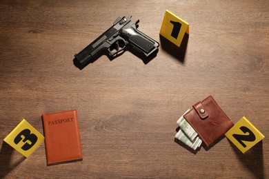 Photo of Forensic expertise. Crime scene with evidence, markers and police tape on wooden background, flat lay