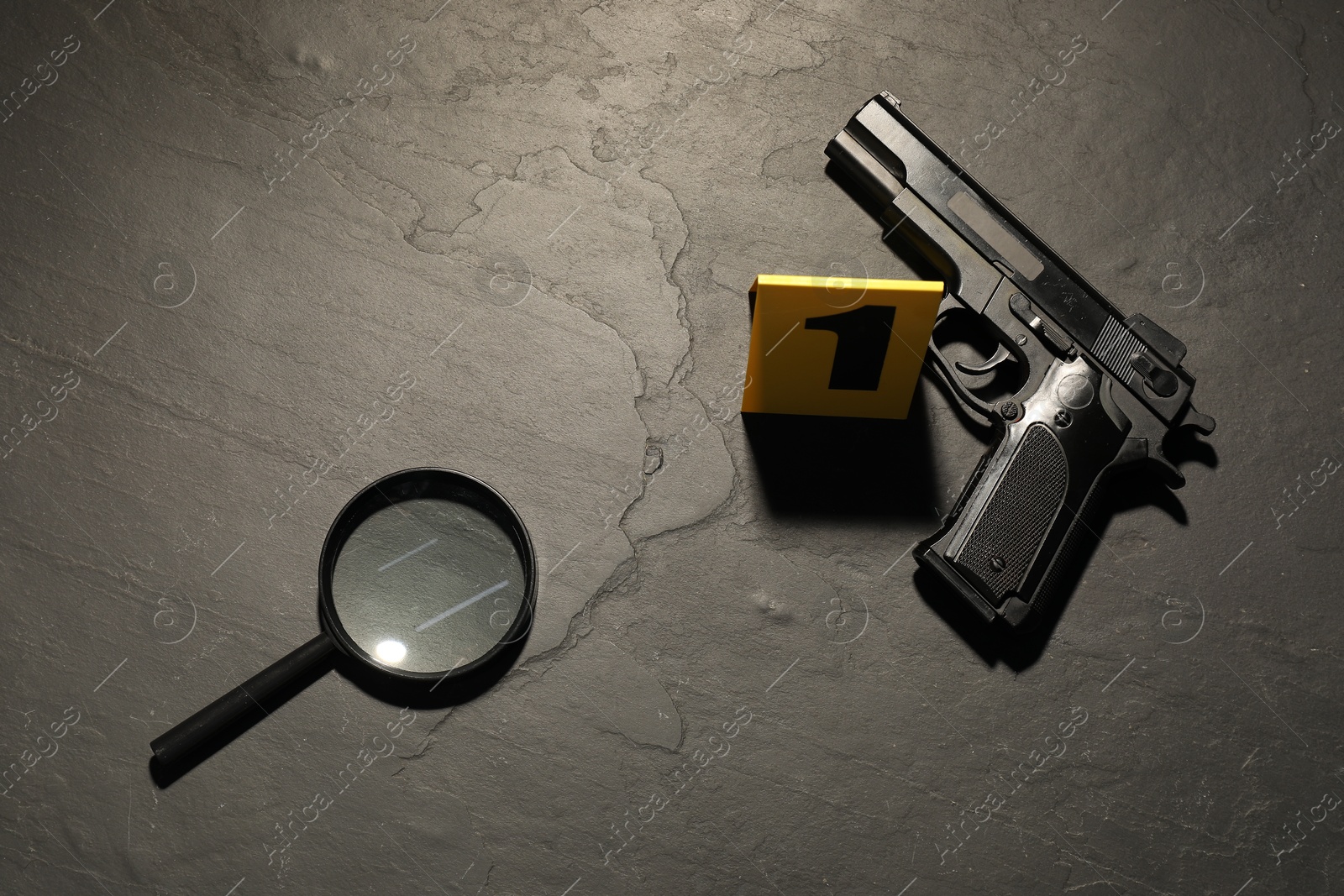 Forensic expertise. Crime scene with gun and magnifying glass on grey background, flat lay Photo of Forensic expertise. Crime scene with gun and magnifying glass on grey background, flat lay