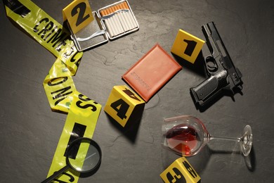 Photo of Forensic expertise. Crime scene with evidence, markers and police tape on grey background, flat lay