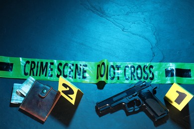 Photo of Forensic expertise. Crime scene with evidence, markers, police tape on blue background, flat lay and space for text. Color toned effect