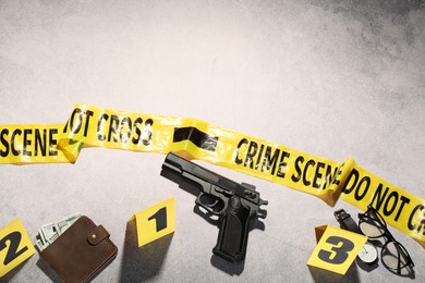 Photo of Forensic expertise. Crime scene with evidence, markers and police tape on light grey background, flat lay. Space for text