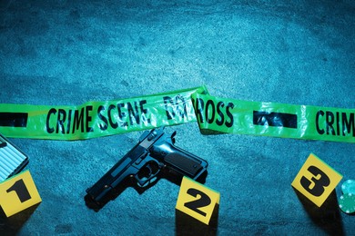 Photo of Forensic expertise. Crime scene with evidence, markers and police tape on blue background, flat lay. Color toned effect