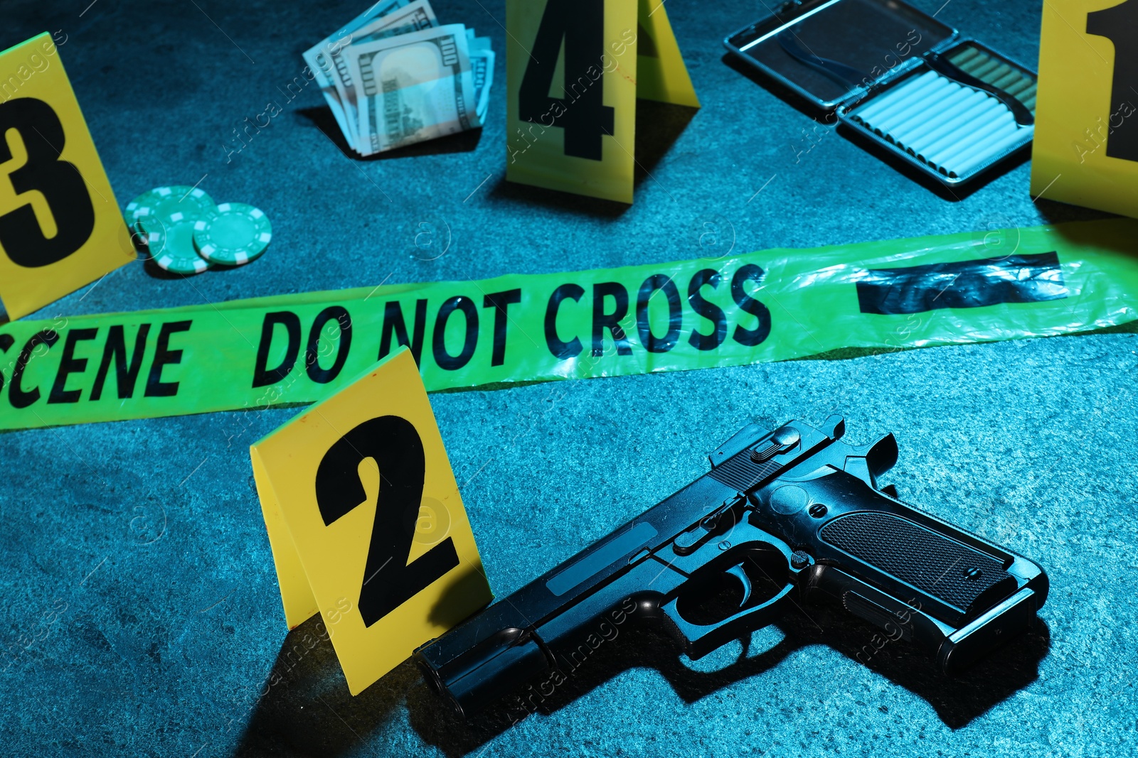 Forensic expertise. Crime scene with evidence, markers and police tape on blue background, closeup. Color toned effect Photo of Forensic expertise. Crime scene with evidence, markers and police tape on blue background, closeup. Color toned effect