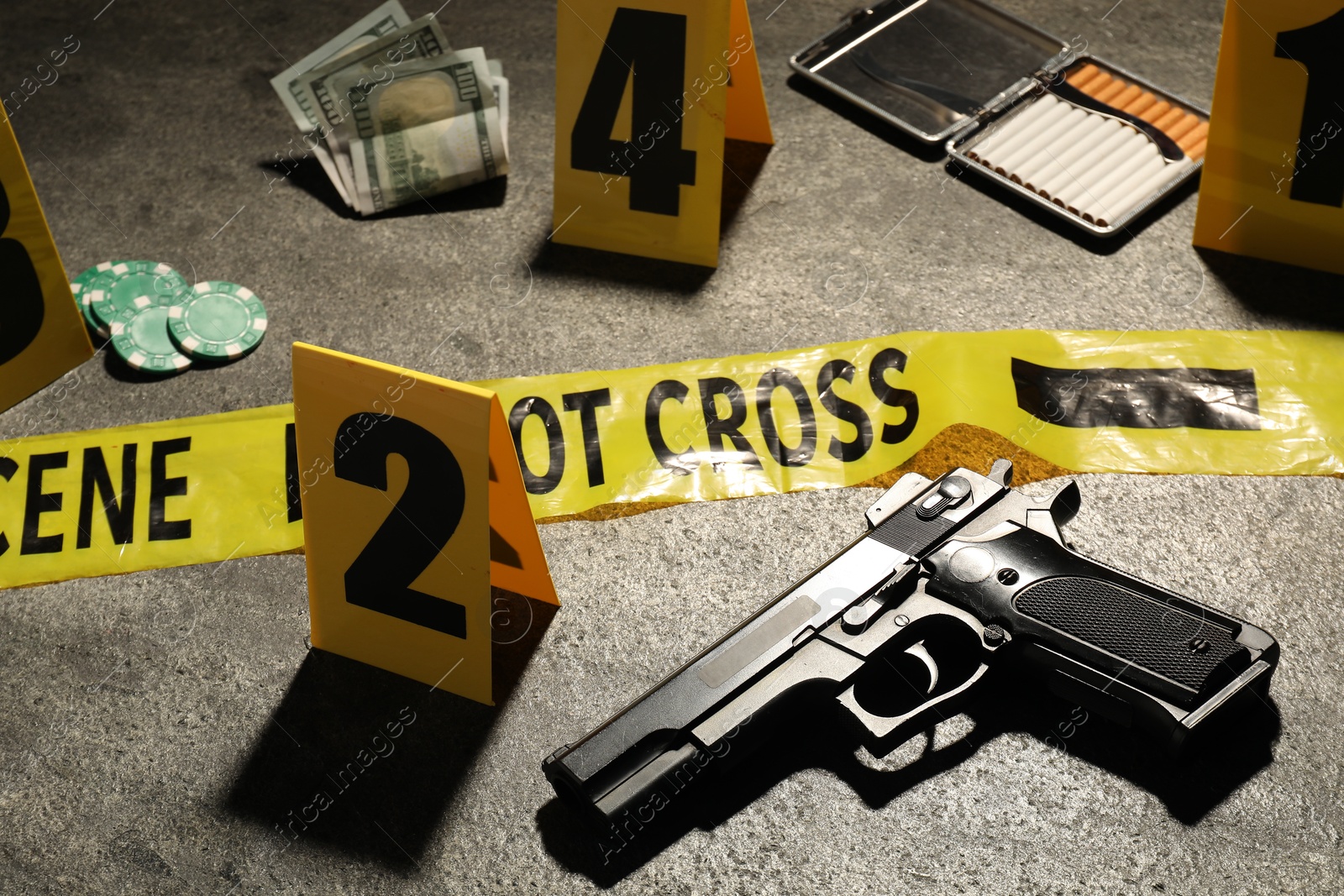 Forensic expertise. Crime scene with evidence, markers and police tape on grey background, closeup Photo of Forensic expertise. Crime scene with evidence, markers and police tape on grey background, closeup