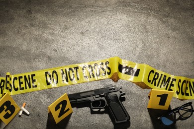 Photo of Forensic expertise. Crime scene with evidence, markers and police tape on grey background, flat lay. Space for text