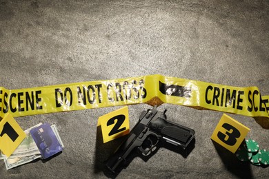 Photo of Forensic expertise. Crime scene with evidence, markers and police tape on grey background, flat lay. Space for text