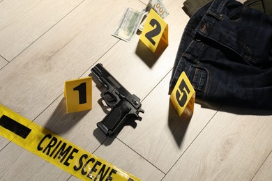 Photo of Forensic expertise. Crime scene with evidence, markers and police tape on floor