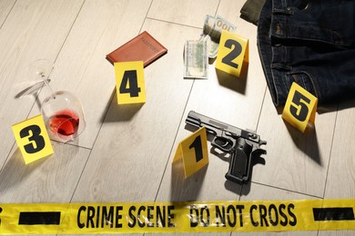 Photo of Forensic expertise. Crime scene with evidence, markers and police tape on floor
