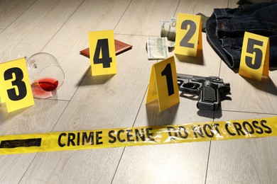 Photo of Forensic expertise. Crime scene with evidence, markers and police tape on floor