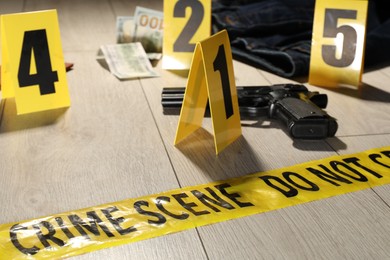 Photo of Forensic expertise. Crime scene with evidence, markers and police tape on floor, closeup