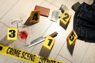 Photo of Forensic expertise. Crime scene with evidence, markers and police tape on floor