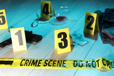 Photo of Forensic expertise. Crime scene with evidence, markers and police tape on floor. Color toned effect