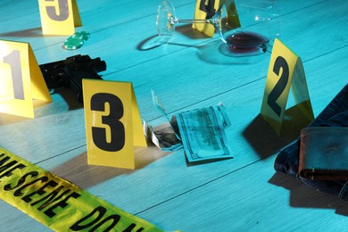 Photo of Forensic expertise. Crime scene with evidence, markers and police tape on floor, closeup. Color toned effect