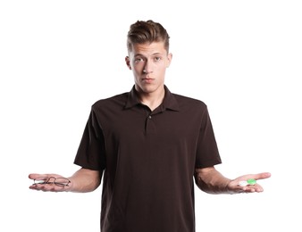 Photo of Man choosing between glasses and contact lenses on white background