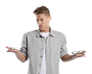 Photo of Man choosing between glasses and contact lenses on white background