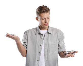 Photo of Man choosing between glasses and contact lenses on white background