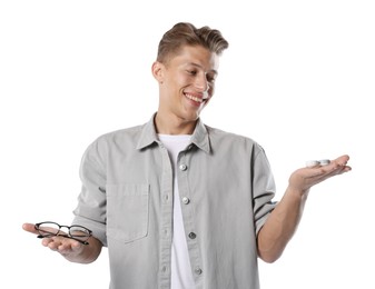 Photo of Man choosing between glasses and contact lenses on white background