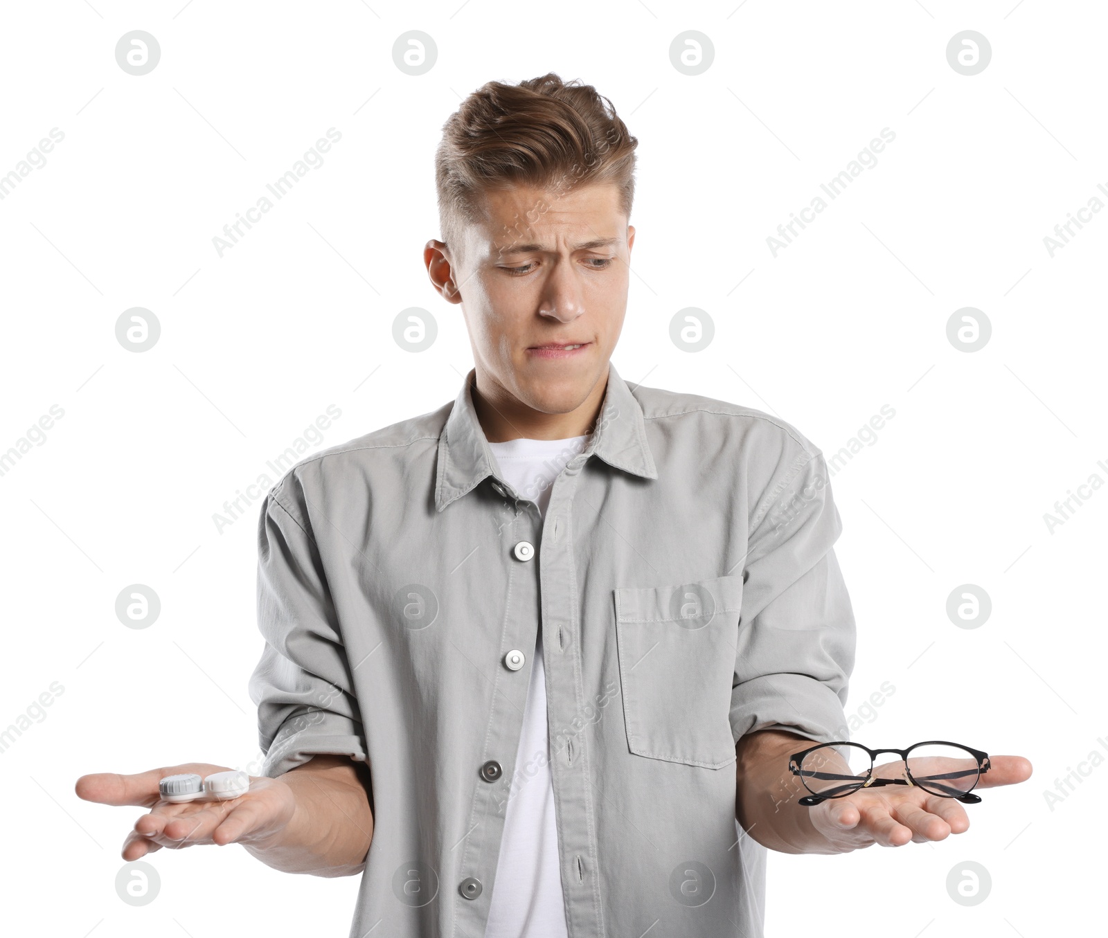 Man choosing between glasses and contact lenses on white background Photo of Man choosing between glasses and contact lenses on white background