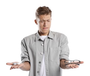 Photo of Man choosing between glasses and contact lenses on white background