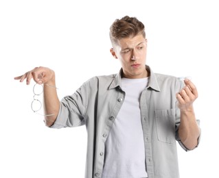 Photo of Man choosing between glasses and contact lenses on white background