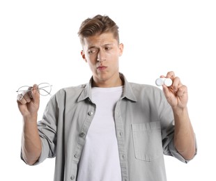 Photo of Man choosing between glasses and contact lenses on white background