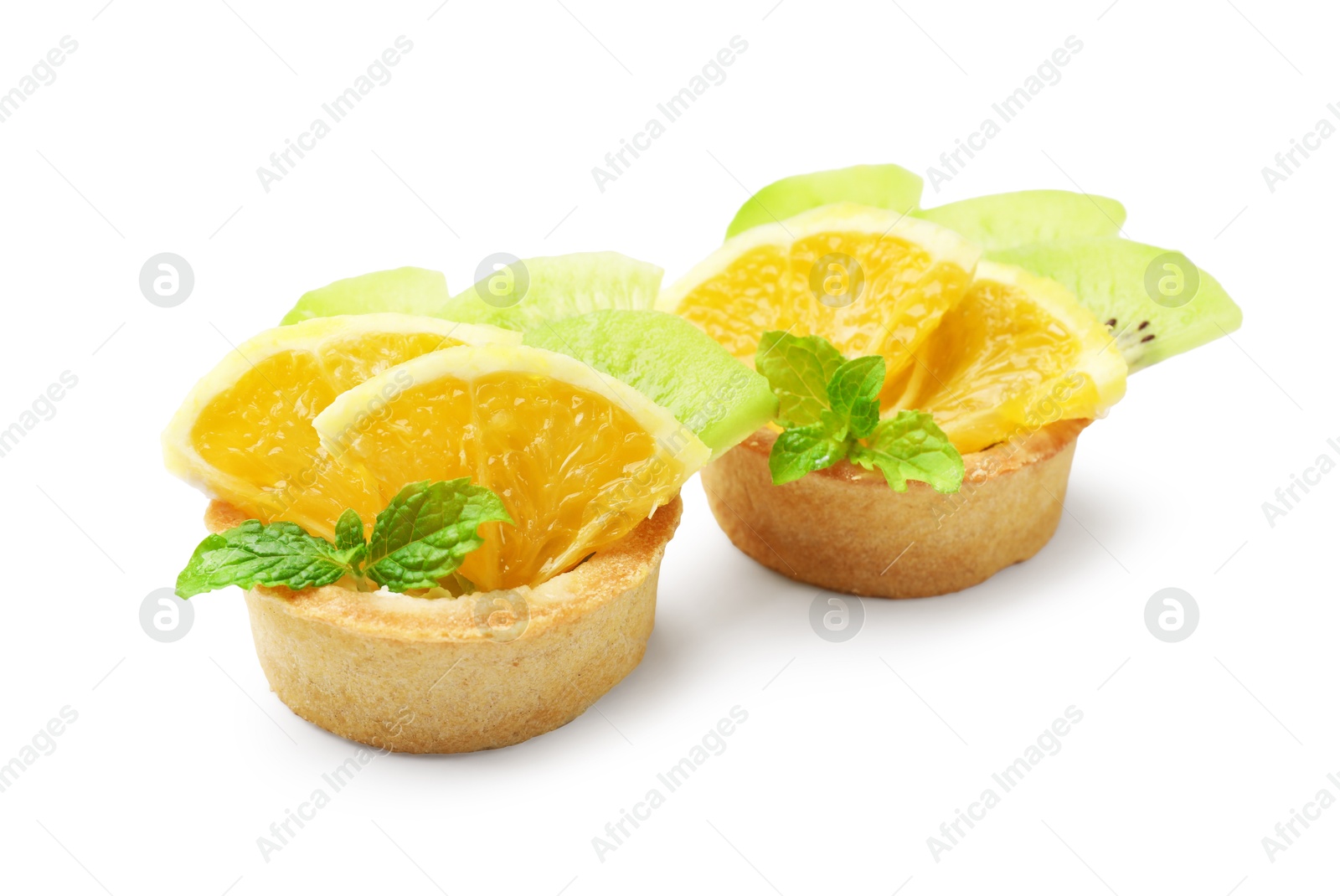 Tartlets with fruits and mint isolated on white. Delicious dessert Photo of Tartlets with fruits and mint isolated on white. Delicious dessert