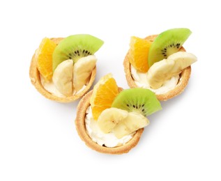Photo of Tartlets with fruits isolated on white, top view. Delicious dessert