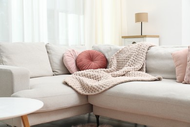 Photo of Woolen blanket and pillows on sofa indoors