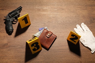 Photo of Forensic expertise. Crime scene with evidence, markers and police tape on wooden background, flat lay