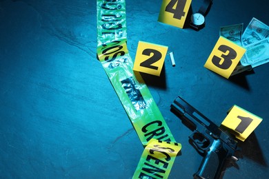 Photo of Forensic expertise. Crime scene with evidence, markers and police tape on blue background, flat lay. Color toned effect