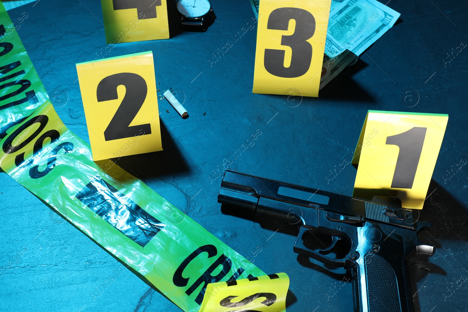 Forensic expertise. Crime scene with evidence, markers and police tape on blue background, closeup. Color toned effect Photo of Forensic expertise. Crime scene with evidence, markers and police tape on blue background, closeup. Color toned effect