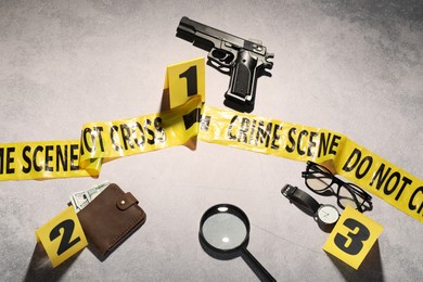 Photo of Forensic expertise. Crime scene with evidence, markers and police tape on light grey background, flat lay