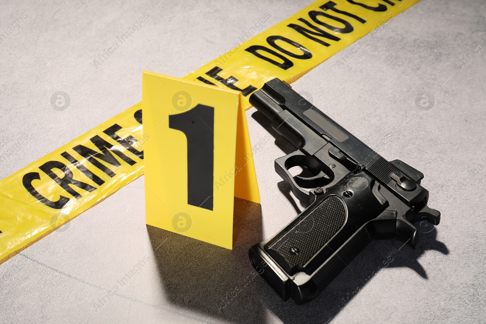 Forensic expertise. Crime scene tape and gun on light grey background, closeup Photo of Forensic expertise. Crime scene tape and gun on light grey background, closeup