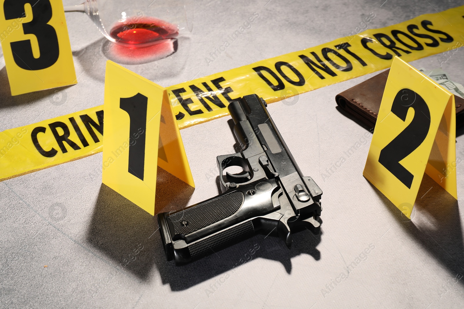 Forensic expertise. Crime scene with evidence, markers and police tape on light grey background, closeup Photo of Forensic expertise. Crime scene with evidence, markers and police tape on light grey background, closeup