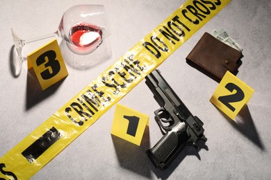 Photo of Forensic expertise. Crime scene with evidence, markers and police tape on light grey background, flat lay