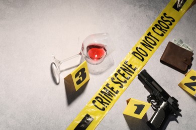 Photo of Forensic expertise. Crime scene with evidence, markers and police tape on light grey background, flat lay